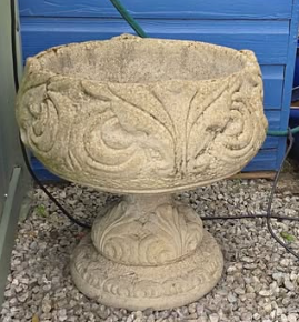 Actual outdoor photograph of one ornamental stone garden urn
